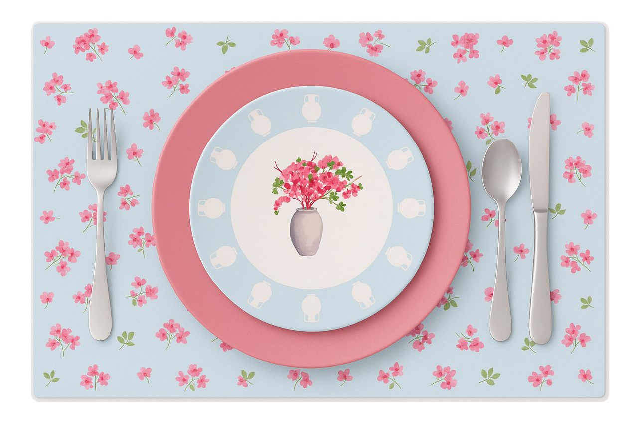 The decal plate on a floral placemat with cutlery