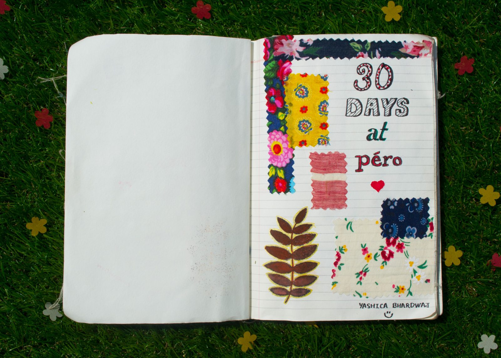 An open journal on grass, its cover collaged with fabric, a dried leaf and the words 30 days at Péro