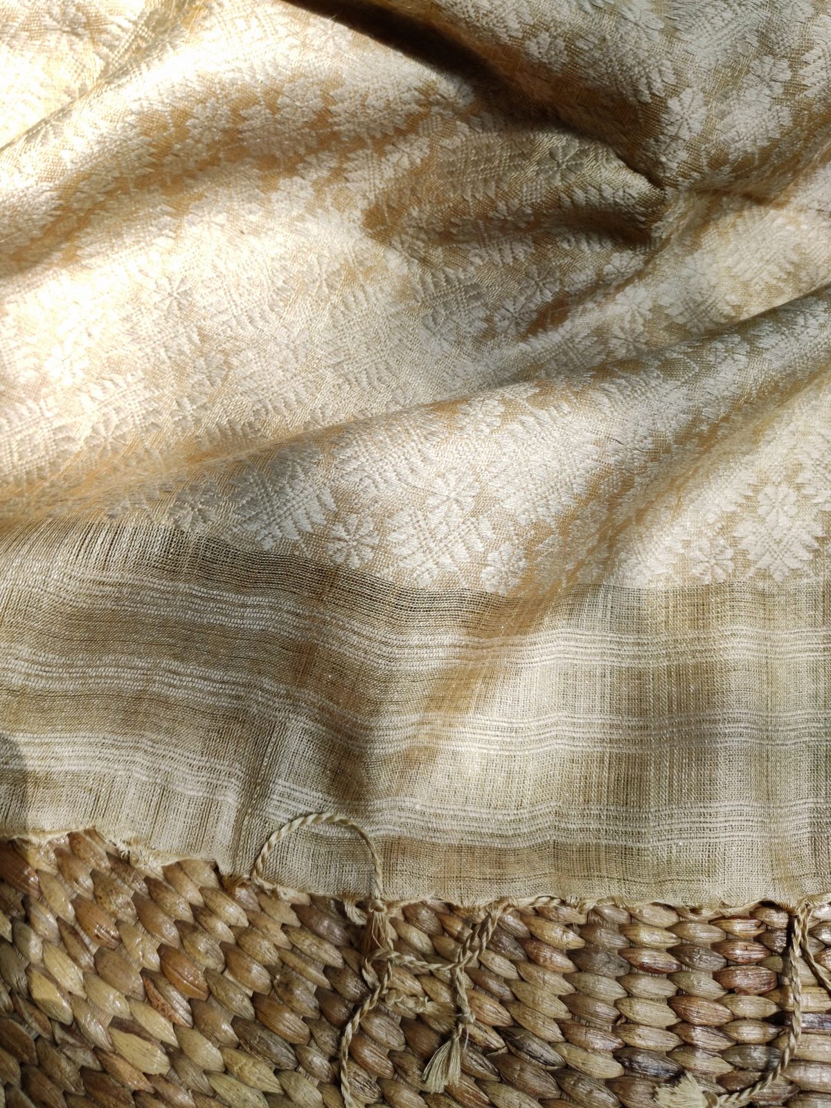 A length of undyed handloom silk with a woven border, folded