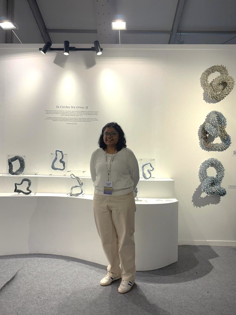 Looped sculptural forms mounted on a white wall and on plinths